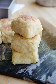 three biscuits stacked on top of each other next to a cutting board with a knife