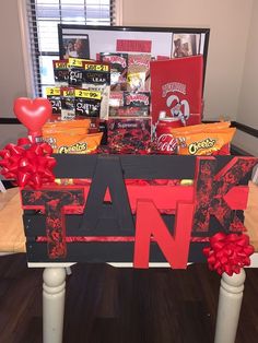 a table that has some candy and candies on it with a red bow around the edge