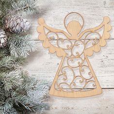 a wooden angel ornament hanging from a pine tree