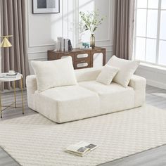 a living room scene with focus on the sofa and pillows, which are off white