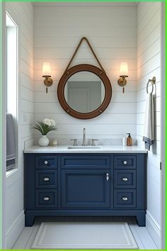 a bathroom with blue cabinets and a round mirror on the wall above it is shown