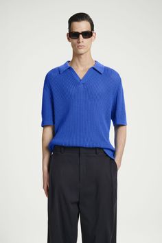 This season, the menswear team take a crafted approach to the classic polo. This electric-blue piece is made from cotton that's open-knitted to create an airiness that's ideal for summer and features a spread collar and side slits to relax the shape. Relaxed fitOrganic cotton is grown from non-genetically modified seeds without chemical fertilizers or pesticides  Shell: 76% Organic cotton, 24% Recycled polyamide. Excluding trims / Machine wash Back length of size M is 25.78" / Model wears a size M Blue Relaxed Fit Polo Shirt, Luxury Blue Relaxed Fit Polo Shirt, Navy Cotton Polo Shirt, Culotte Shorts, Blue Moisture-wicking Collared Polo Shirt, Blue Cotton Polo Collar T-shirt, Genetically Modified, Vest Shirt, Jumpsuit Trousers