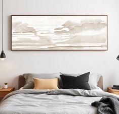 a bed sitting under a painting in a bedroom