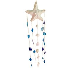 a starfish hanging from the ceiling with shells and sea glass on it's side