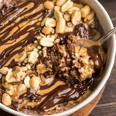 chocolate peanut butter oatmeal in a bowl with a spoon full of nuts