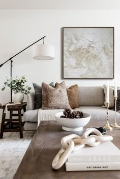 a living room filled with furniture and a painting on the wall above it's coffee table