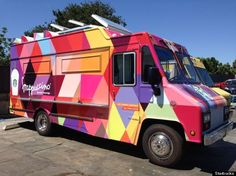 a colorful food truck is parked on the street