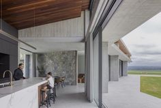 two people sitting at a bar in front of a stone wall and open floor plan