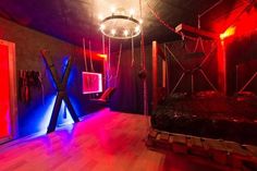 a bedroom with red and blue lights on the walls, wood floors and a bed