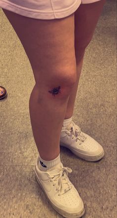 a person with a small spider tattoo on their leg