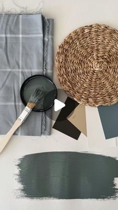 a table with some paint samples and a brush on it next to a wicker basket