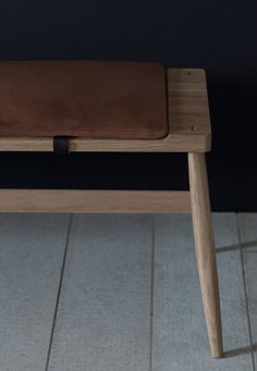 a wooden bench sitting on top of a tiled floor