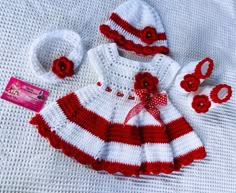 a red and white knitted baby outfit with matching hat