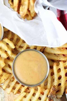 some waffles are on a plate with dipping sauce in the middle and another item next to them