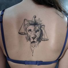 a woman's back with a lion and scales tattoo on her left side shoulder