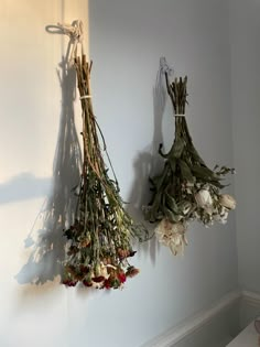 dried flowers hang from hooks on the wall