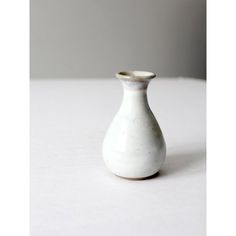 a small white vase sitting on top of a table