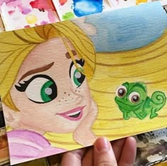 a person holding up a drawing of a princess and frog