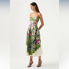 a woman is wearing a dress with flowers on it