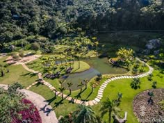 an aerial view of a lush green park with lots of trees and water in the middle