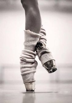 the legs and feet of a ballerina in ballet shoes with their socks wrapped around them