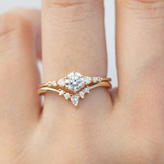 a woman's hand with a diamond ring on top of her finger and an engagement band