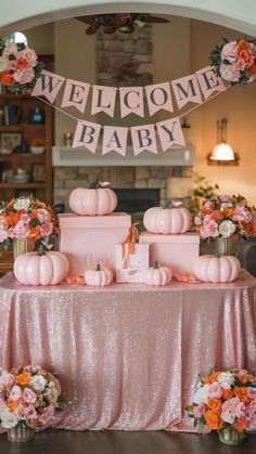 a welcome baby sign on top of a table with cupcakes and pink flowers