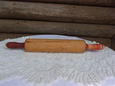 a wooden rolling pin sitting on top of a white doily