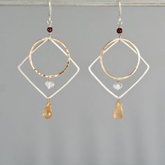 These modern earrings feature two handmade geometric shapes. They are made from 14k yellow gold filled and sterling silver. They are given flat and hammered texture and a shiny finish. The ear wires are sterling silver. This pair has deep red garnet along with pale aquamarine and yellow citrine drops. Measures 2 1/2" long including the ear wires. Boho Earrings Diy, Metal Jewelry Handmade, Geometric Hoop Earrings, Bling Earrings, Handmade Fashion Jewelry, Beaded Drop Earrings, Handmade Jewelry Diy