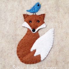 a felt fox with a blue bird sitting on top of it