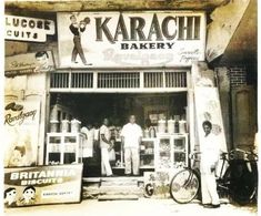 an old black and white photo of men in front of a bakery