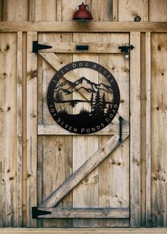 a wooden sign on the side of a building with mountains in the backround