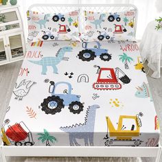 a child's bed with a tractor and farm animals printed on the sheet set