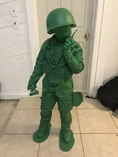 a toy soldier is standing in front of a door and talking on a cell phone