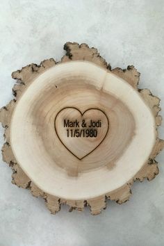 a wooden slice with a heart on it and the date marked mark & jodi