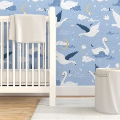 a baby's room with blue wallpaper and white crib in the foreground