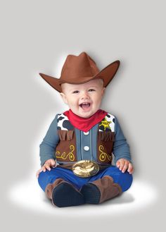 a baby wearing a cowboy hat sitting on the floor