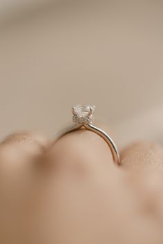 a person's hand with a diamond ring on it