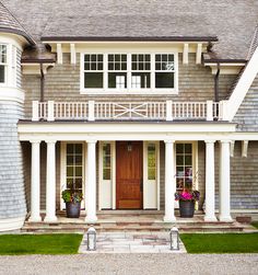 the front entrance to a large house with white columns