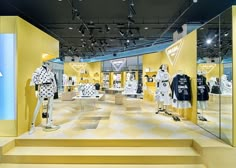 a store display with yellow walls and white mannequins dressed in polka dots