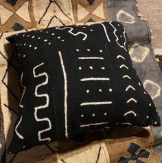 a black and white pillow sitting on top of a rug