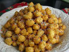 a white plate topped with fried food covered in sprinkles