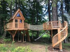 a tree house with a hammock in the middle of it's yard