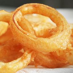 some onion rings are sitting on top of a white napkin and there is no image here to provide a caption for