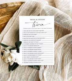 a white flower on top of a table with a sign that says 20 questions about the bride