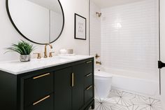 a white and black bathroom with gold accents