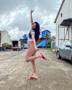 a young woman is dancing on the street