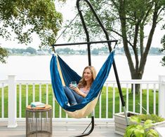 a woman sitting in a hammock on a deck