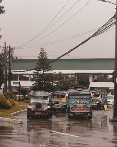 several buses are parked in front of a gas station