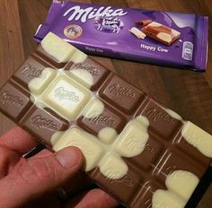 a hand holding a bar of milk chocolate